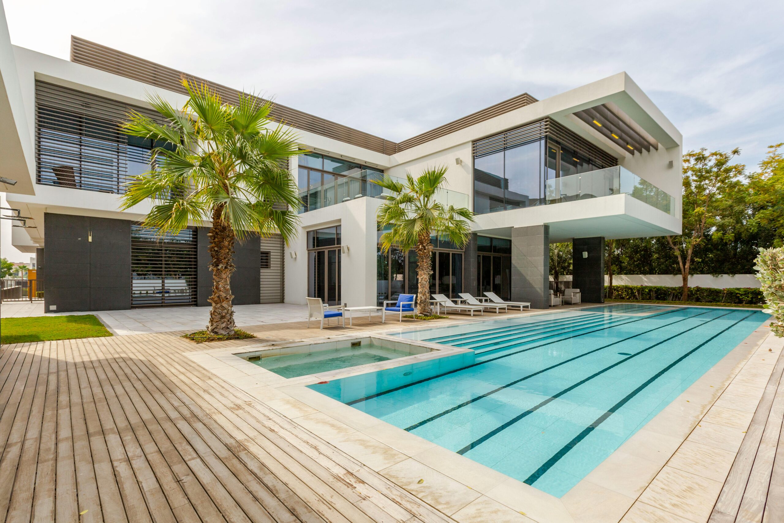 Nos biens Explore this luxurious modern villa in Dubai with a stunning swimming pool and palm trees.