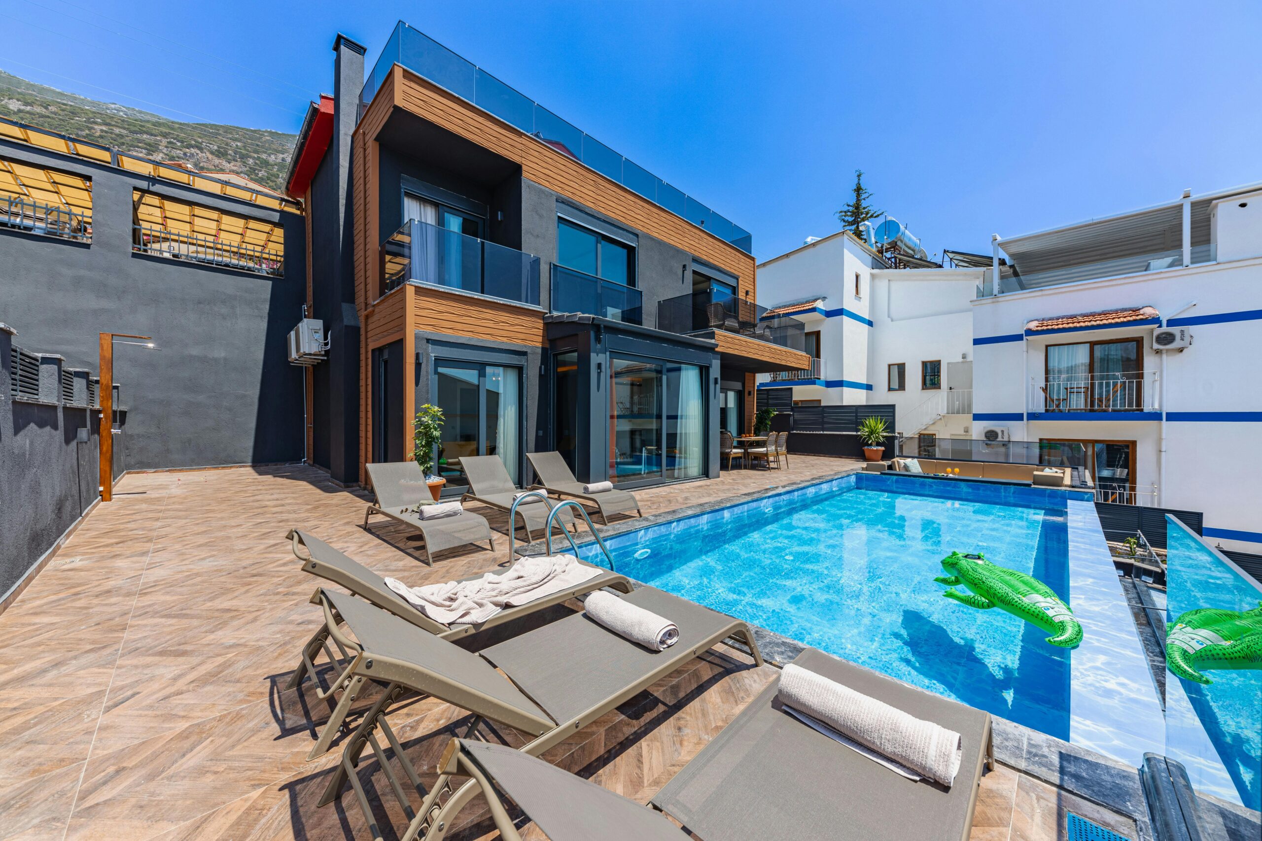 Nos biens Contemporary villa with a private swimming pool and sun loungers, ideal for a luxury vacation.