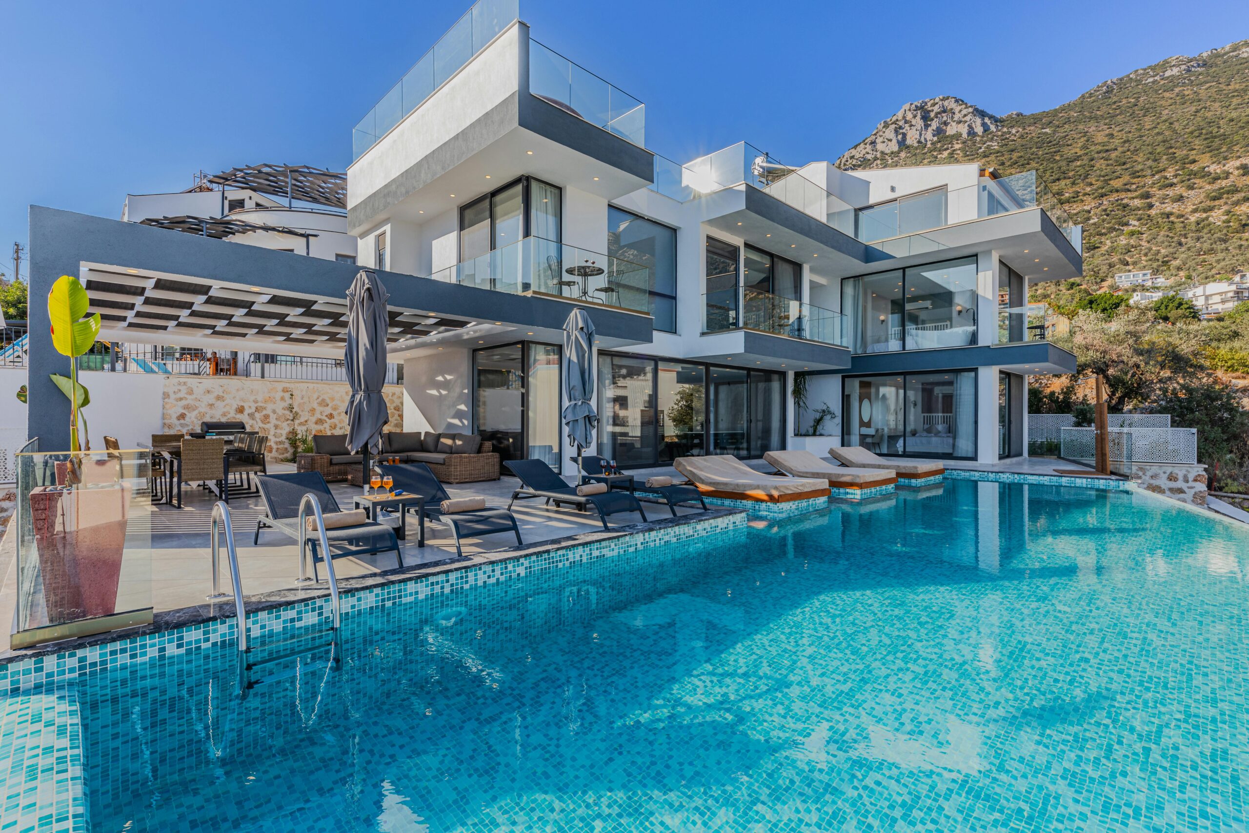 Nos biens Stunning contemporary villa featuring a spacious infinity pool and breathtaking mountain backdrop.