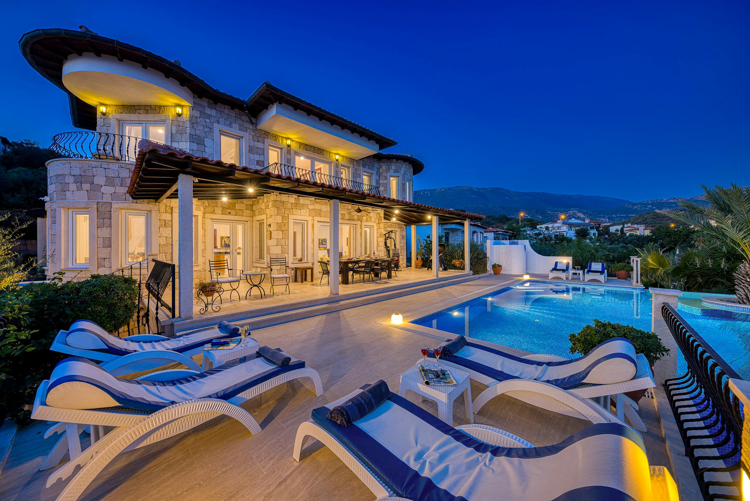 Nos biens Stunning villa with poolside view during dusk, perfect for a luxurious vacation stay.