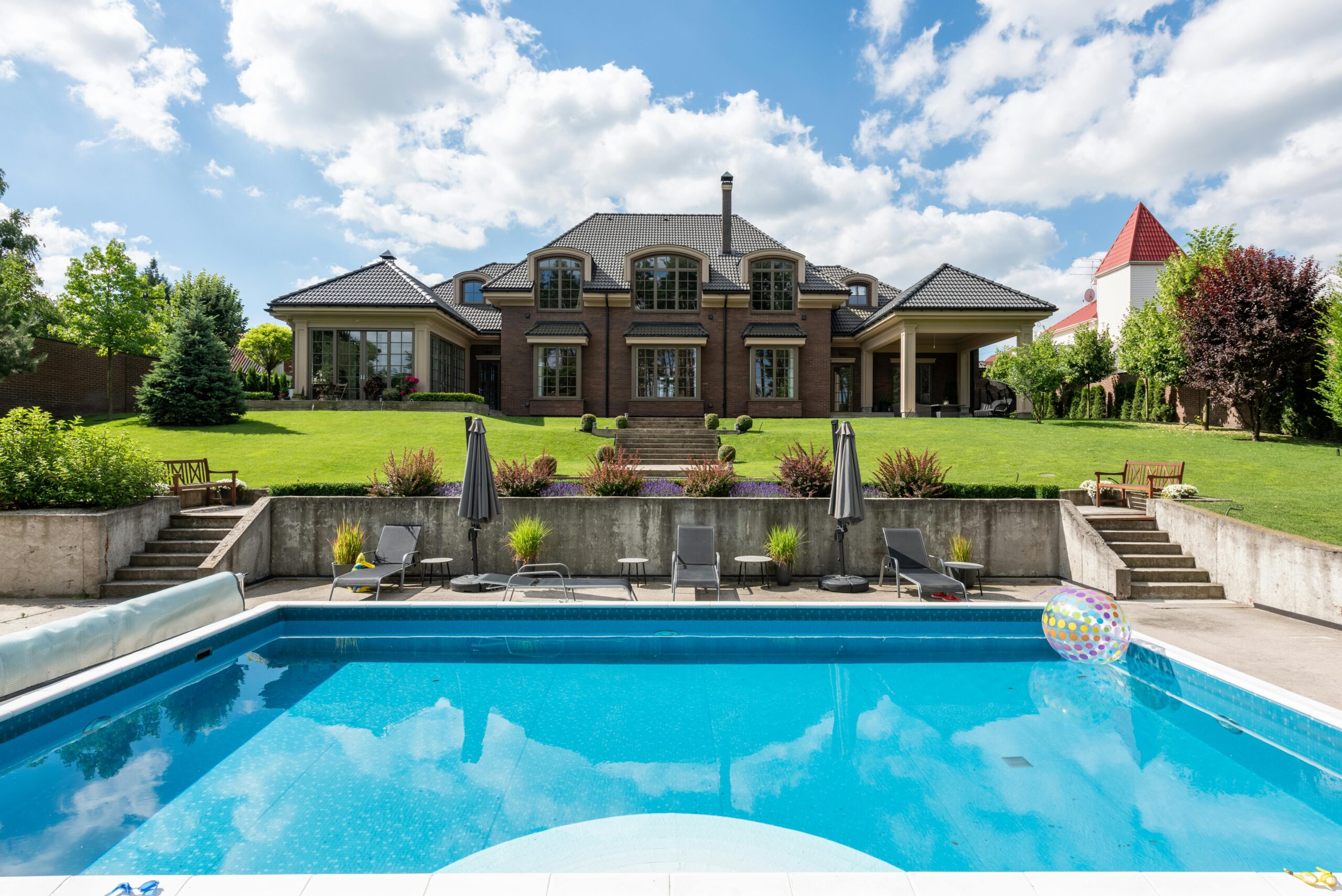 Nos biens Elegant mansion with a sparkling pool and well-maintained garden, ideal for luxury living.